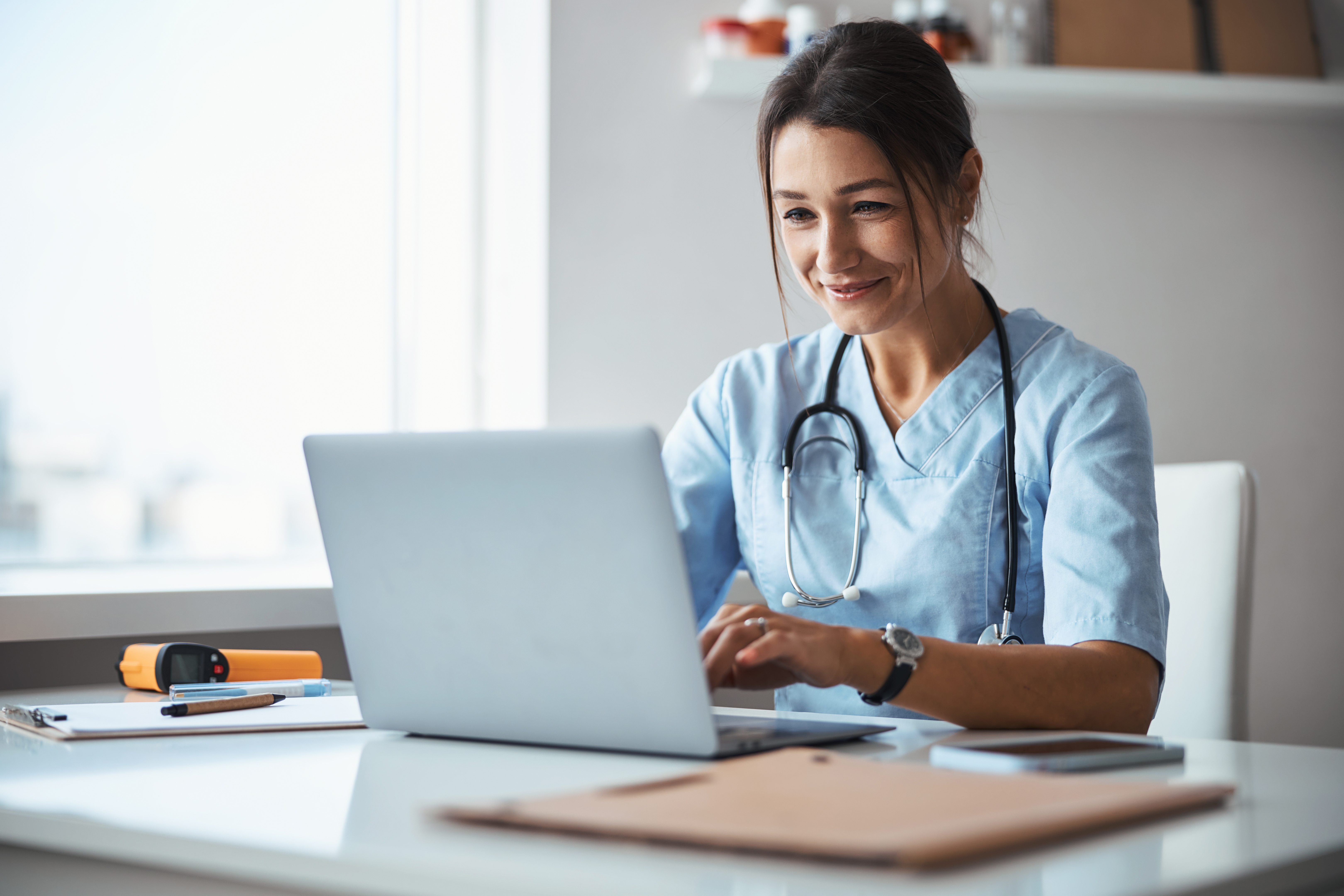 Healthcare professional reviewing roles on a laptop